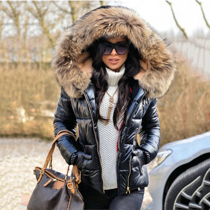 Frau in schwarzer Daunenjacke mit Fellkapuze, Sonnenbrille und Handtasche. Wintermode, Outdoor, stilvoll, warm, modisch.