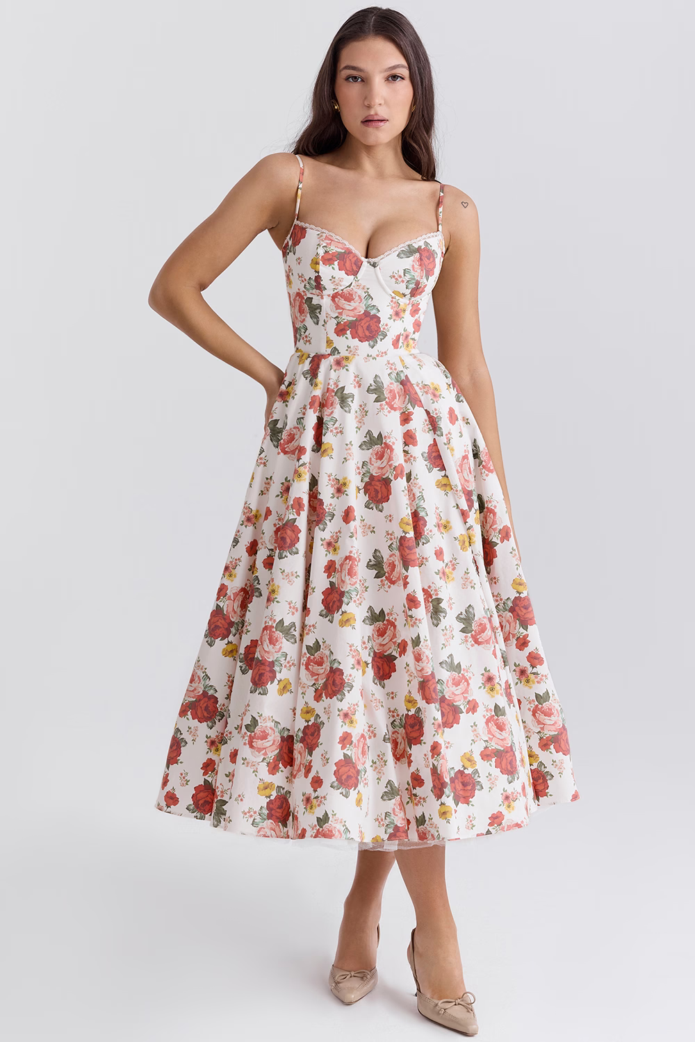 Frau in weißem, geblümtem Kleid mit Spaghettiträgern und herzförmigem Ausschnitt, knielang, elegante Mode, Sommerkleid, Blumenmuster.