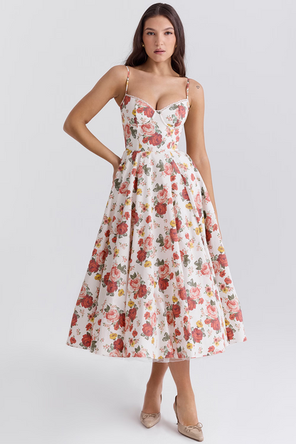 Frau in weißem, geblümtem Kleid mit Spaghettiträgern und herzförmigem Ausschnitt, knielang, elegante Mode, Sommerkleid, Blumenmuster.
