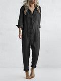 Frau in schwarzem Jumpsuit vor weißem Hintergrund, modisch, lässig, langärmelig, elegantes Design, Damenmode, minimalistischer Stil.