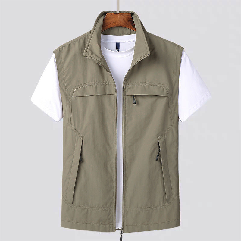 Beige Herrenweste mit Reißverschluss über weißem T-Shirt, hängend auf Holzkleiderbügel. Outdoor-Mode, Freizeitkleidung, ärmellose Jacke.