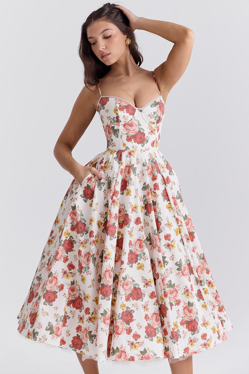 Frau in geblümtem Sommerkleid, Vintage-Stil, mit Rosenmuster, ärmellos, knielang, elegantes Design, Modefotografie, stilvolle Damenbekleidung.