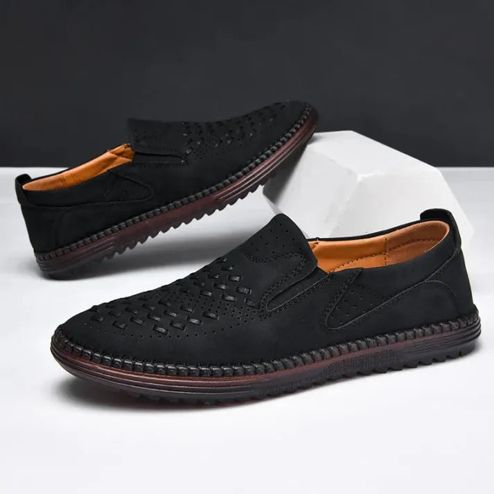 Schwarze Herren-Slipper aus Leder mit perforiertem Design, rutschfester Sohle und bequemer Passform. Elegante Freizeitschuhe für den Alltag.