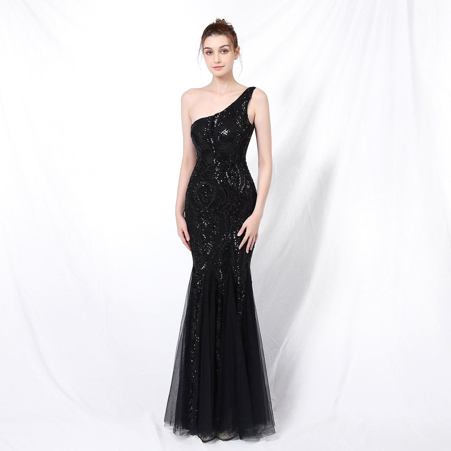 Frau in elegantem, schwarzem, schulterfreiem Abendkleid mit Pailletten vor weißem Hintergrund. Perfekt für Gala, Ball oder formelle Anlässe.