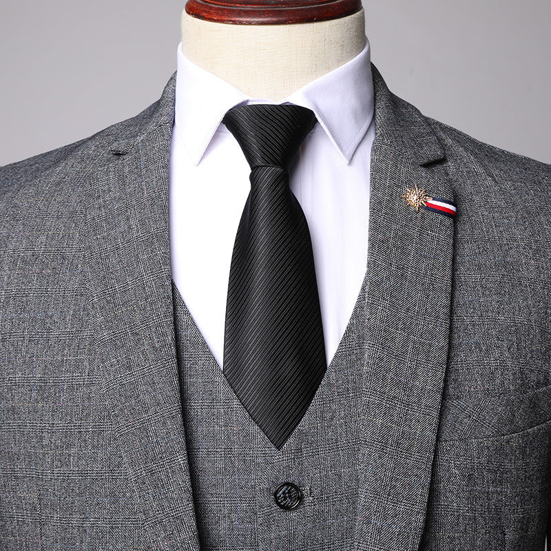 Grauer Herrenanzug mit schwarzer Krawatte und weißem Hemd, elegantes Design, Anstecknadel, Businessmode, formelle Kleidung, stilvoller Look.