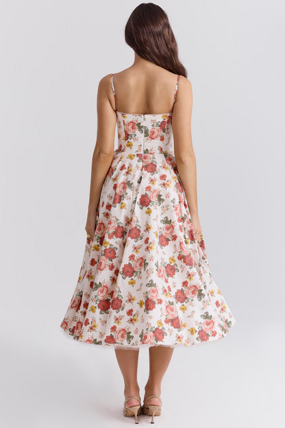 Frau in geblümtem Sommerkleid, Rückansicht. Weißes Midikleid mit roten Blumen, schmalen Trägern. Elegante Mode, ideal für Sommeranlässe.