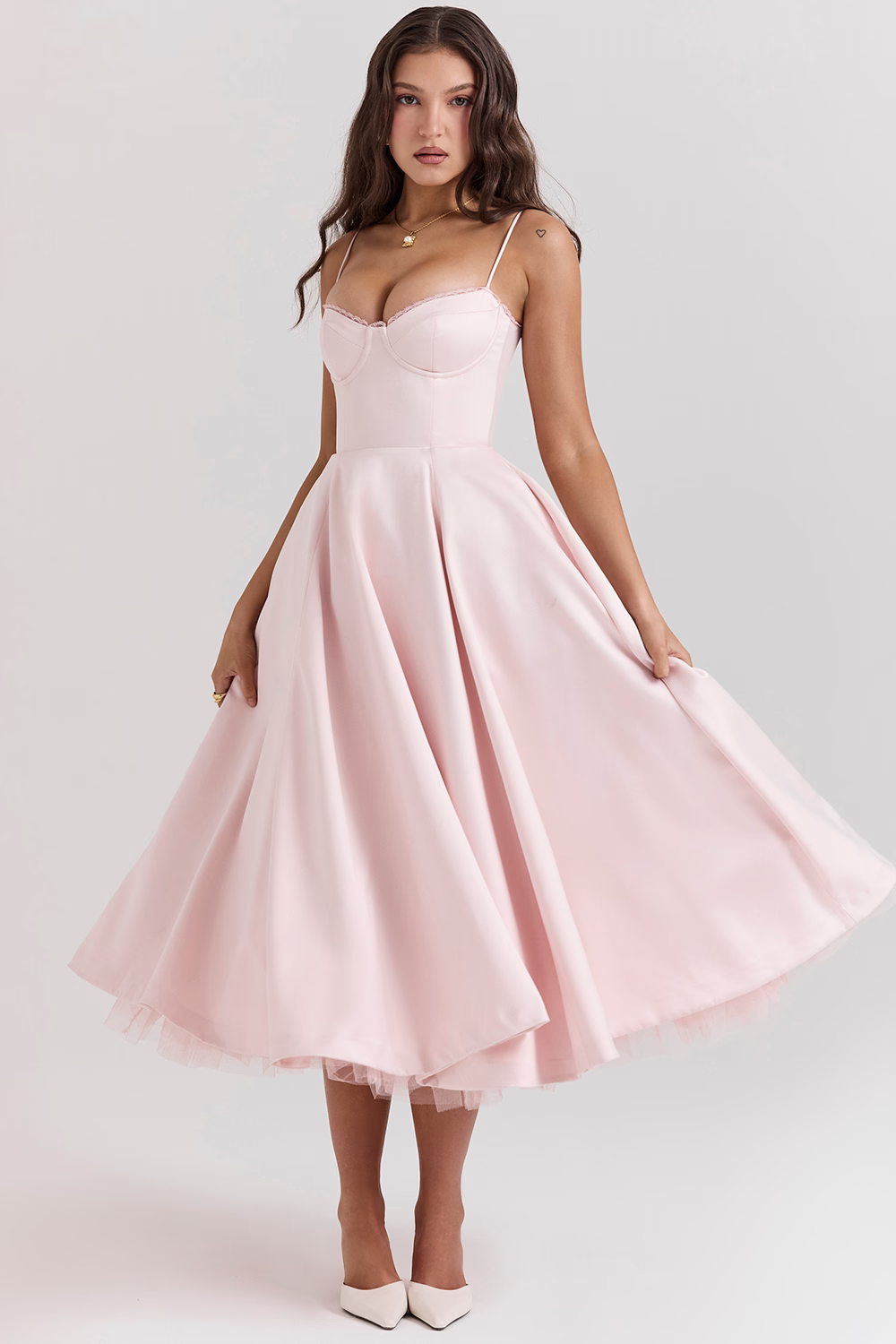 Frau in rosa Abendkleid mit Spaghettiträgern und ausgestelltem Rock, elegante Mode, festliche Kleidung, stilvolle Abendgarderobe.
