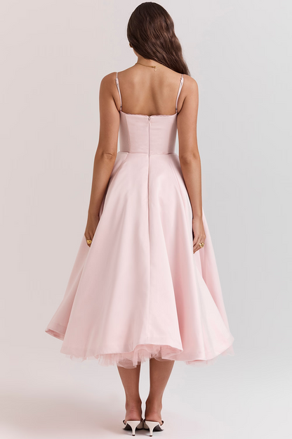 Frau in rosa Cocktailkleid mit Spaghettiträgern, Rückansicht. Elegantes Design, knielang, ideal für Abendveranstaltungen.