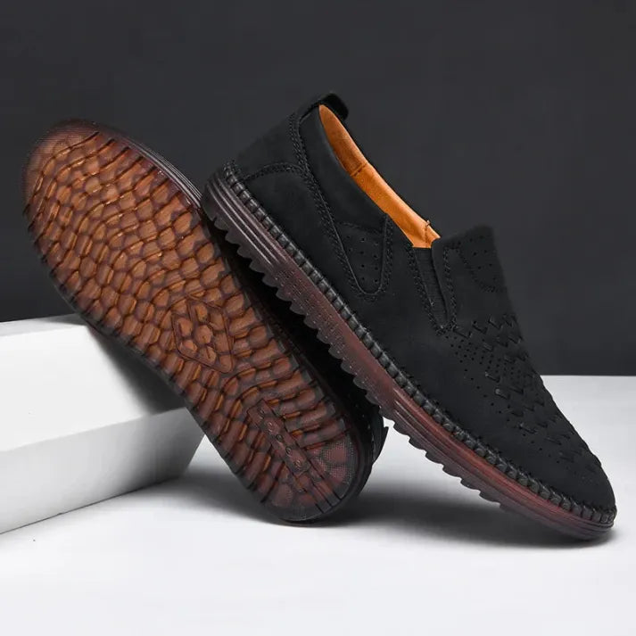 Schwarze Herren-Slipper aus Wildleder mit rutschfester Sohle, elegantem Design und perforierten Details, ideal für Freizeit und Business.