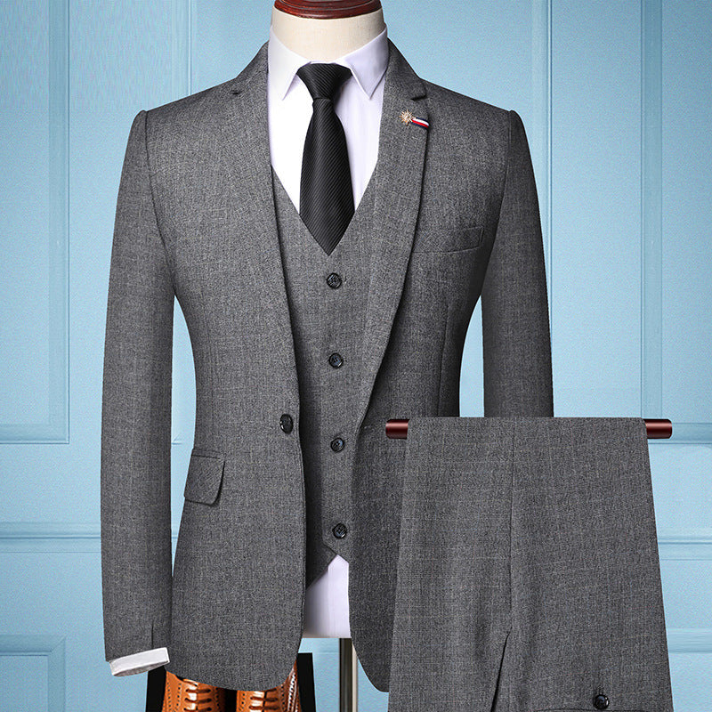 Grauer Herrenanzug mit Weste und Krawatte, elegant und modern, vor blauem Hintergrund. Perfekt für Business und formelle Anlässe.