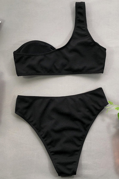 Schwarzer asymmetrischer Bikini mit einem Schulterträger und hochgeschnittener Taille, ideal für Strandmode und Sommertrends.