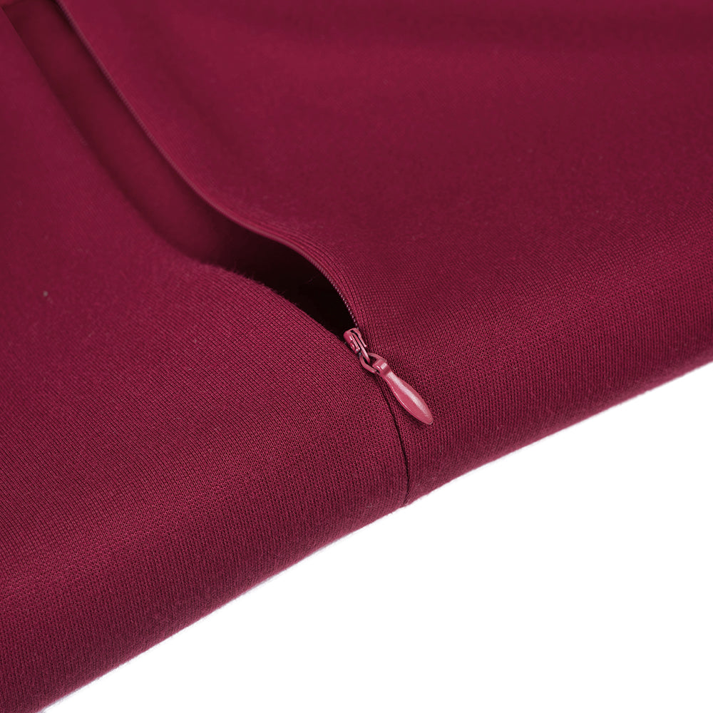 Bordeauxroter Reißverschluss an einem Kleidungsstück, Nahaufnahme. Hochwertiger Stoff, elegante Verarbeitung, modisches Design.