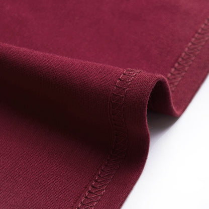 Bordeauxroter Baumwollstoff mit feiner Naht, Nahaufnahme. Hochwertiger Textilstoff, ideal für Bekleidung und Heimtextilien.