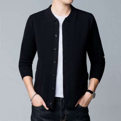 Mann in schwarzer Strickjacke, weißem T-Shirt und Jeans. Mode, Herrenbekleidung, lässiger Stil, Armbanduhr, grauer Hintergrund.