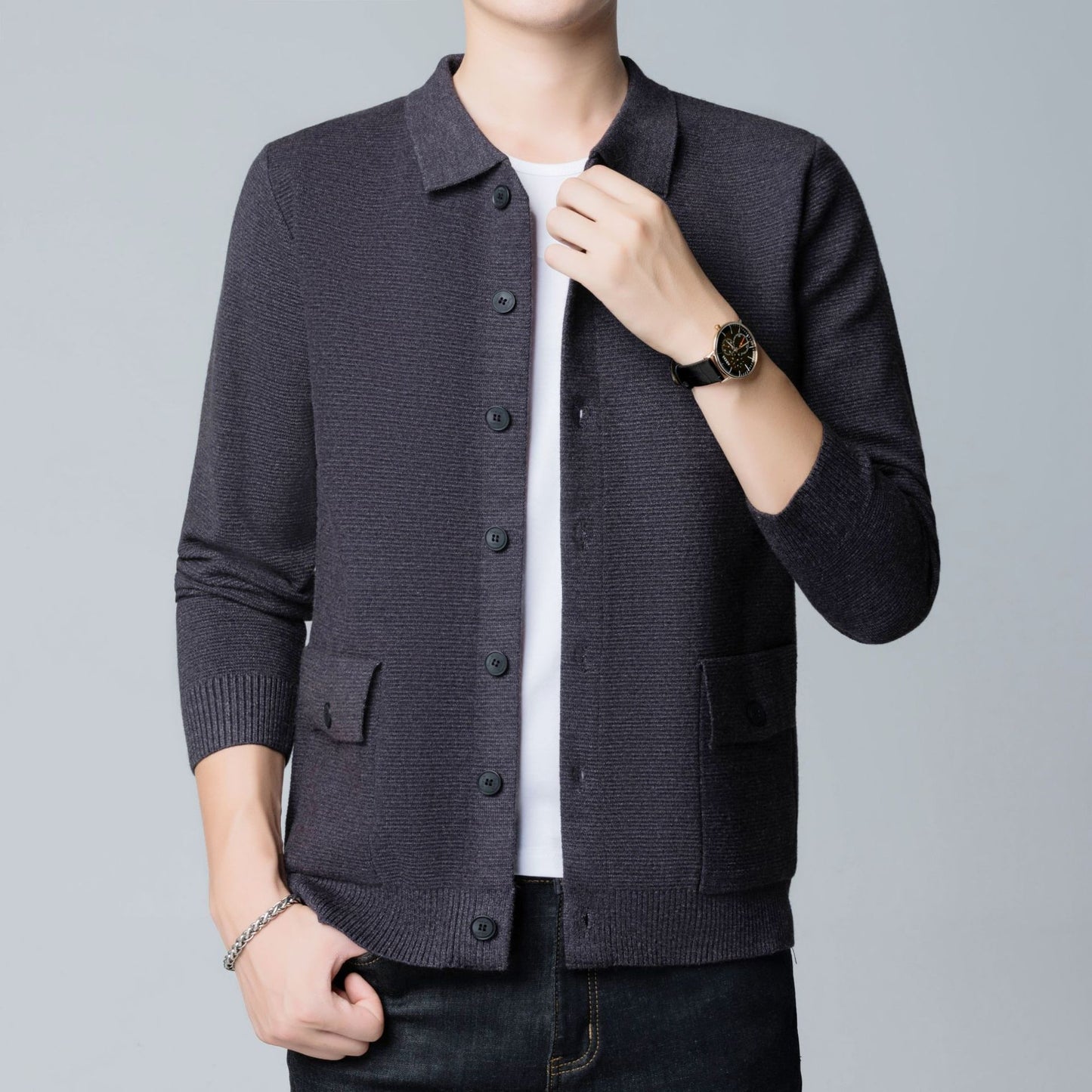 Dunkelgrauer Strick-Cardigan für Herren, getragen über weißem T-Shirt, kombiniert mit schwarzer Uhr und Armband. Elegante Herrenmode, Freizeitlook.