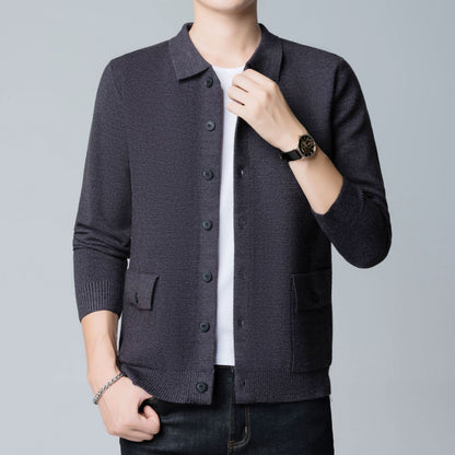 Dunkelgrauer Strick-Cardigan für Herren, getragen über weißem T-Shirt, kombiniert mit schwarzer Uhr und Armband. Elegante Herrenmode, Freizeitlook.