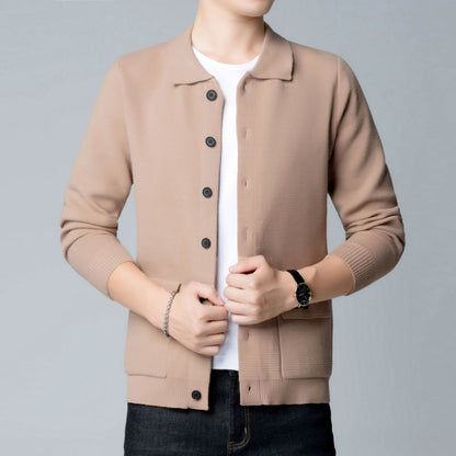 Person in beigefarbener Strickjacke mit schwarzen Knöpfen, weißem T-Shirt und schwarzer Uhr. Mode, Herrenbekleidung, lässiger Stil.