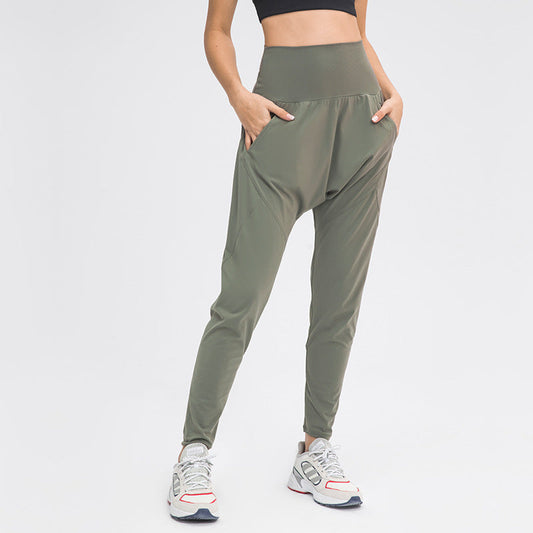 Frau in olivgrüner Haremshose und Sneakers, sportlich, modern, bequem, ideal für Yoga oder Freizeit, modische Damenbekleidung.
