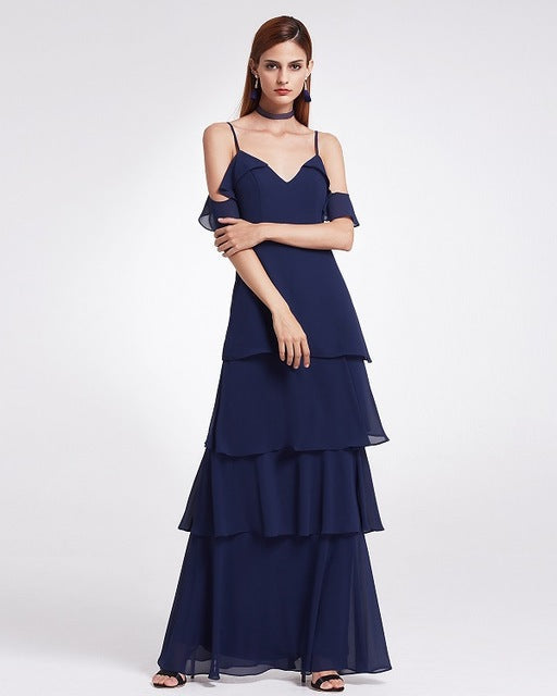 Frau in elegantem, dunkelblauem Abendkleid mit Stufenrock und schulterfreiem Design, ideal für formelle Anlässe und Abendveranstaltungen.