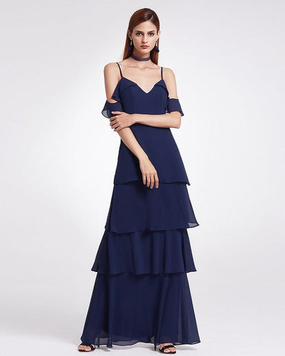 Frau in elegantem, dunkelblauem Abendkleid mit Stufenrock und schulterfreiem Design, ideal für formelle Anlässe und Abendveranstaltungen.
