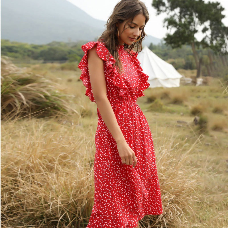 Frau im roten, gepunkteten Kleid mit Rüschen in einer natürlichen Landschaft, Zelt im Hintergrund, Sommermode, Outdoor-Fotografie.