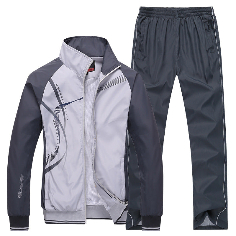 Grauer Trainingsanzug für Herren, bestehend aus Jacke mit grafischem Muster und passender Hose. Sportbekleidung, Freizeitmode, atmungsaktiv.