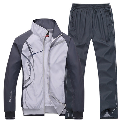 Grauer Trainingsanzug für Herren, bestehend aus Jacke mit grafischem Muster und passender Hose. Sportbekleidung, Freizeitmode, atmungsaktiv.