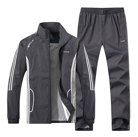 Grauer Trainingsanzug für Herren, bestehend aus Jacke und Hose, mit weißen Streifen und Reißverschluss. Sportbekleidung, atmungsaktiv, modisch.