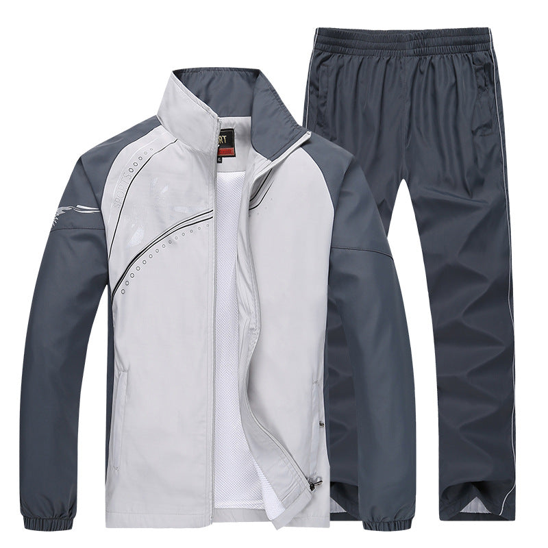 Grauer Trainingsanzug für Herren, bestehend aus Jacke und Hose, mit sportlichem Design und Reißverschluss. Ideal für Fitness und Freizeit.