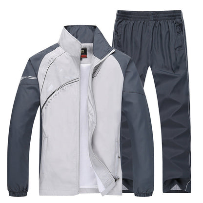 Grauer Trainingsanzug für Herren, bestehend aus Jacke und Hose, mit sportlichem Design und Reißverschluss. Ideal für Fitness und Freizeit.