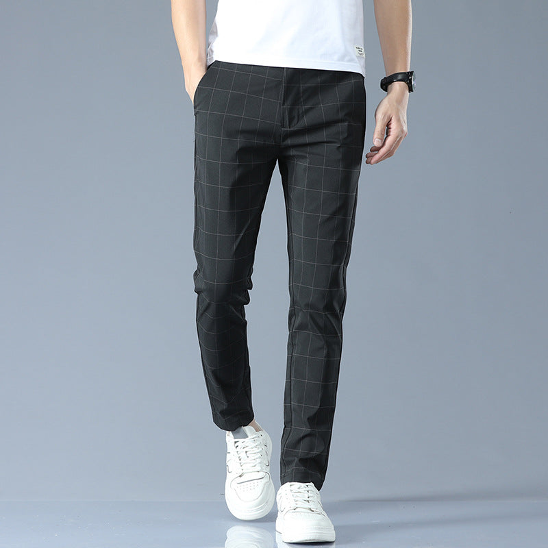 Schwarze karierte Herren-Chinohose, kombiniert mit weißen Sneakers und weißem T-Shirt, ideal für lässige und stilvolle Outfits.