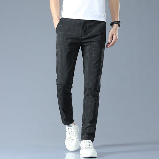 Schwarze karierte Herren-Chinohose, kombiniert mit weißen Sneakers und weißem T-Shirt, ideal für lässige und stilvolle Outfits.