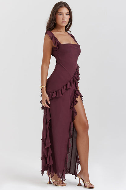 Frau in elegantem, weinrotem Abendkleid mit Rüschen und hohem Beinschlitz, goldene Sandalen, modisches Outfit, stilvolle Abendmode.