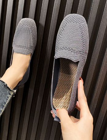 Graue, gestrickte Damen-Loafer auf dunklem Hintergrund, modisch und bequem, ideal für Freizeit und Alltag, stilvolle Schuhe für Damen.