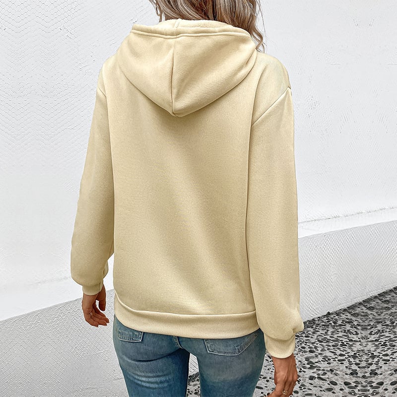 Frau in beigem Hoodie und blauer Jeans von hinten, lässiger Stil, urbaner Hintergrund. Ideal für Mode, Streetwear, Freizeitkleidung.