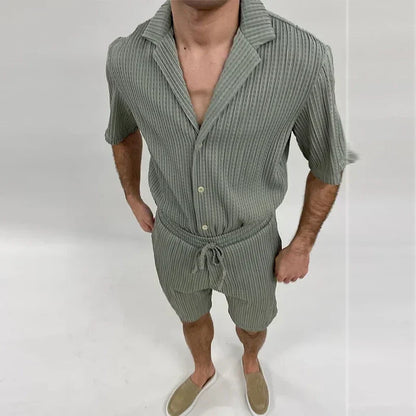 Mann in grauem, geripptem Kurzarm-Hemd und Shorts-Set, lässiger Sommerlook, beige Slipper, modische Herrenbekleidung, vertikale Streifen.