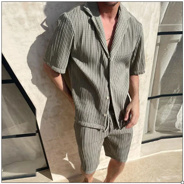 Mann in gestreiftem, kurzärmligem Leinenanzug vor modernem, beigem Hintergrund. Sommermode, Herrenbekleidung, lässiger Stil.