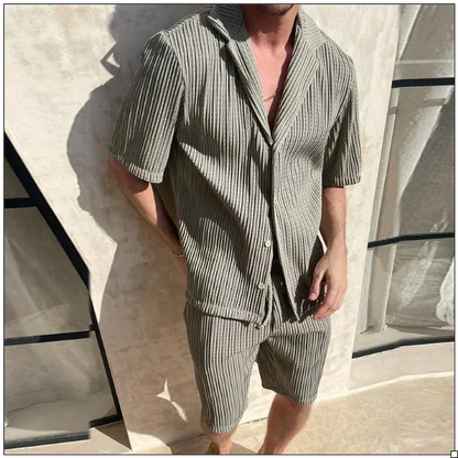 Mann in gestreiftem, kurzärmligem Leinenanzug vor modernem, beigem Hintergrund. Sommermode, Herrenbekleidung, lässiger Stil.
