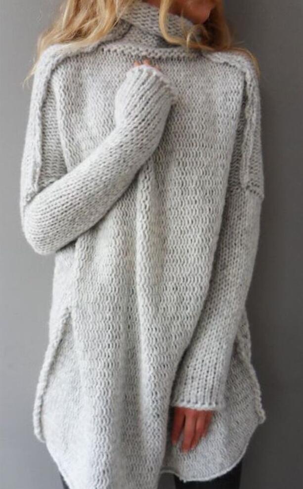 Frau trägt grauen, grob gestrickten Oversize-Pullover mit Rollkragen. Modetrend, gemütlicher Winterlook, Damenmode, Strickmode.