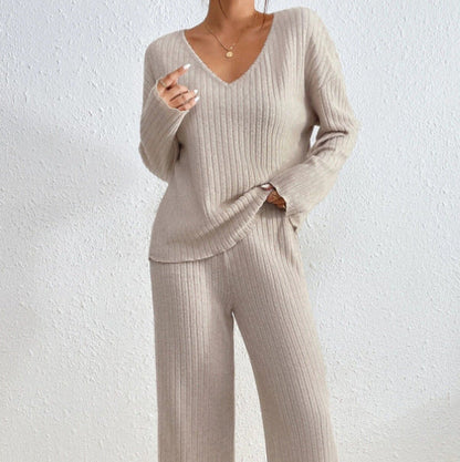 Frau in beigem Strickpullover und Hose, modisches Herbst-Outfit, gemütlicher Look, V-Ausschnitt, minimalistisch, eleganter Stil, Texturdetails.