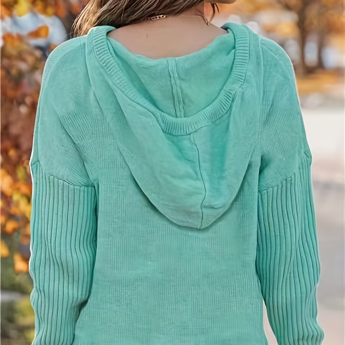 Frau in mintgrünem Kapuzenpullover aus Strick, Herbsthintergrund, modischer Damenpullover, gemütlicher Herbstlook, stilvolle Freizeitkleidung.