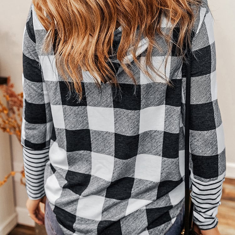 Frau mit langen, welligen Haaren trägt kariertes Hemd in Schwarz-Weiß. Modetrend, Herbstmode, lässiger Stil, Rückansicht.