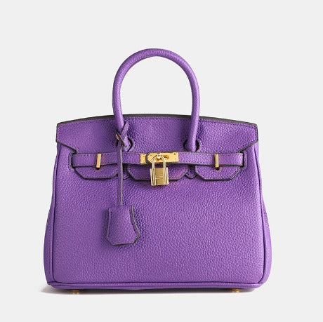 Lila Designer-Handtasche aus Leder mit goldenen Beschlägen und Schloss, luxuriöses Accessoire, modisches Statement, elegantes Design.