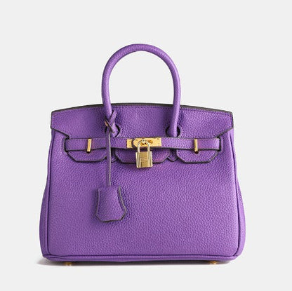 Lila Designer-Handtasche aus Leder mit goldenen Beschlägen und Schloss, luxuriöses Accessoire, modisches Statement, elegantes Design.