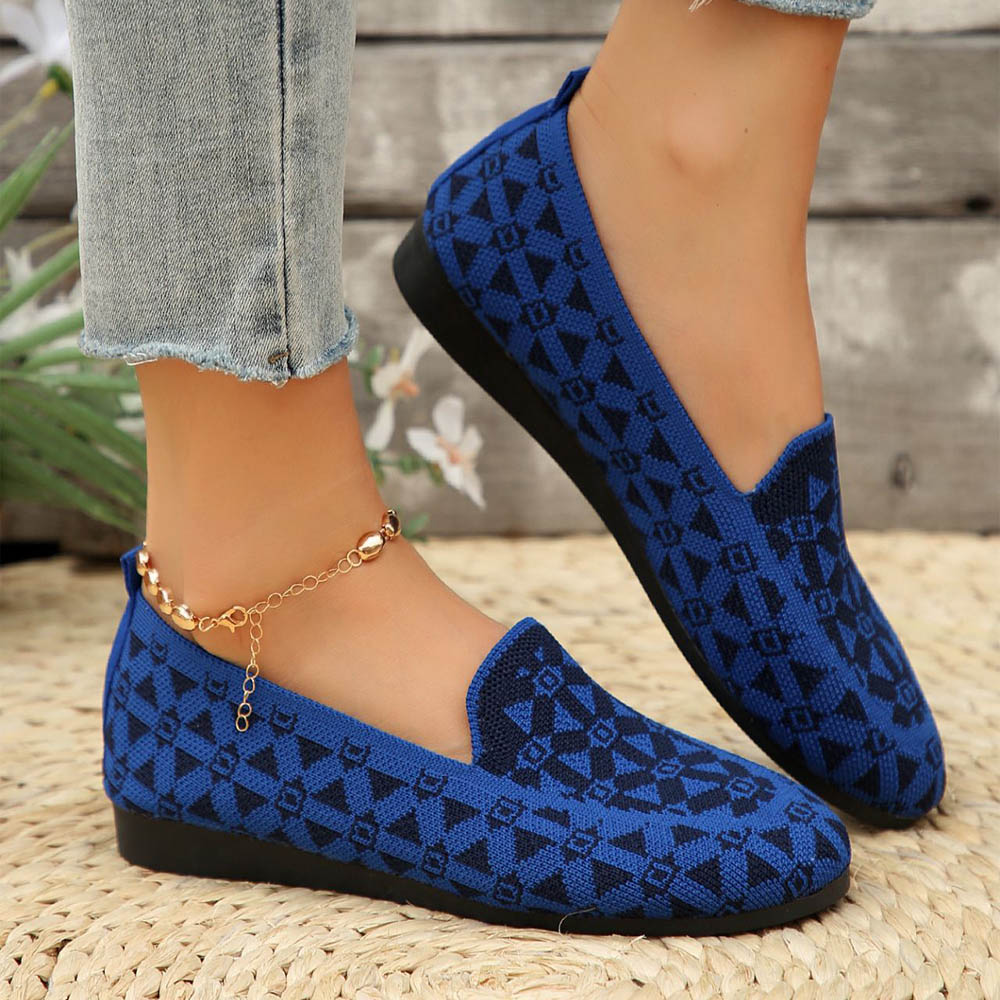 Blaue Damen-Loafer mit geometrischem Muster, getragen mit Jeans und goldener Fußkette. Modische Freizeitschuhe für den Sommer.