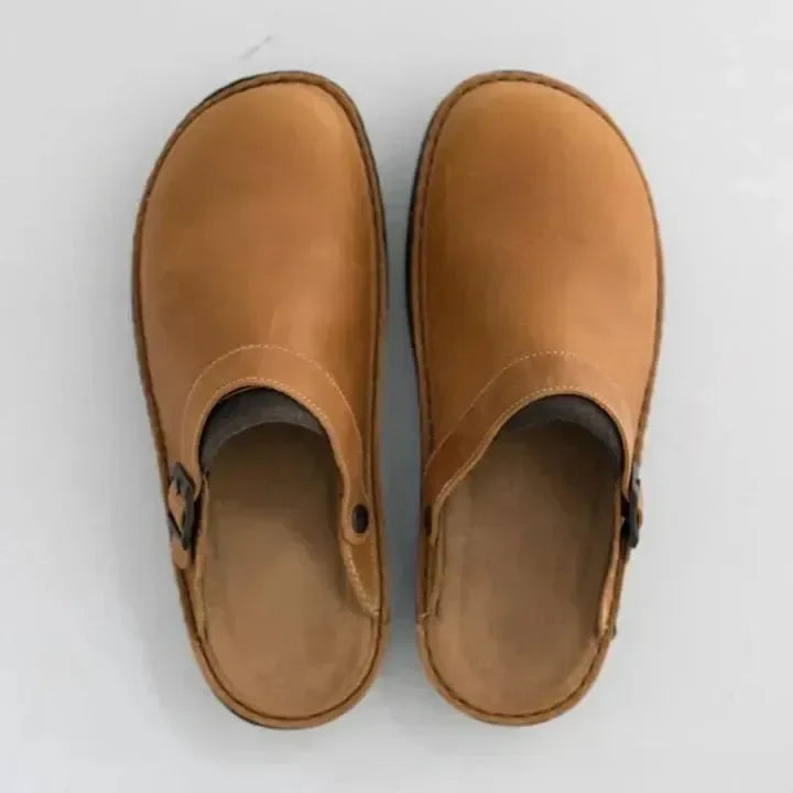 Braune Leder-Clogs mit Schnalle, minimalistisch und modern, auf weißem Hintergrund. Bequeme, stilvolle Schuhe für Alltag und Freizeit.