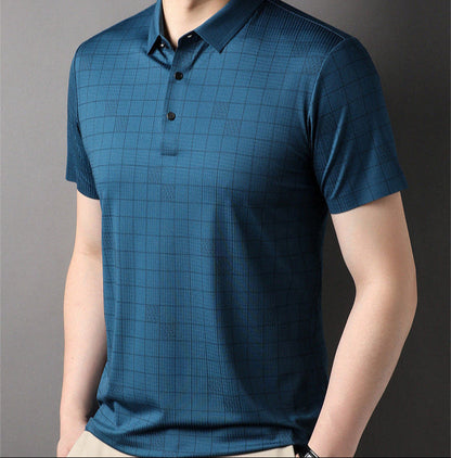 Mann in blauem kariertem Poloshirt vor grauem Hintergrund, modische Herrenbekleidung, kurzärmeliges Shirt, Freizeitmode, eleganter Look.