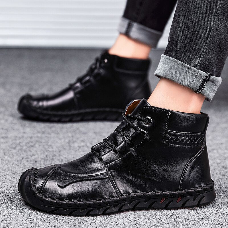 Schwarze Herren-Lederstiefel, lässig und modern, auf grauem Teppichboden. Perfekt für Herbstmode und urbanen Stil.