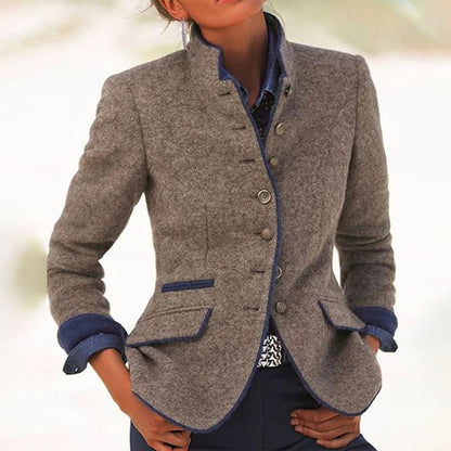 Grauer Damenblazer mit blauen Akzenten, Stehkragen und Knopfleiste. Elegante Herbstmode, ideal für Business und Freizeit.