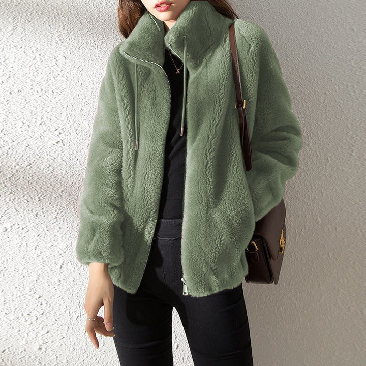 Frau in grüner Kunstpelzjacke, schwarze Hose, braune Umhängetasche, modisch, Herbstmode, stilvoll, warm, elegant, Damenbekleidung.